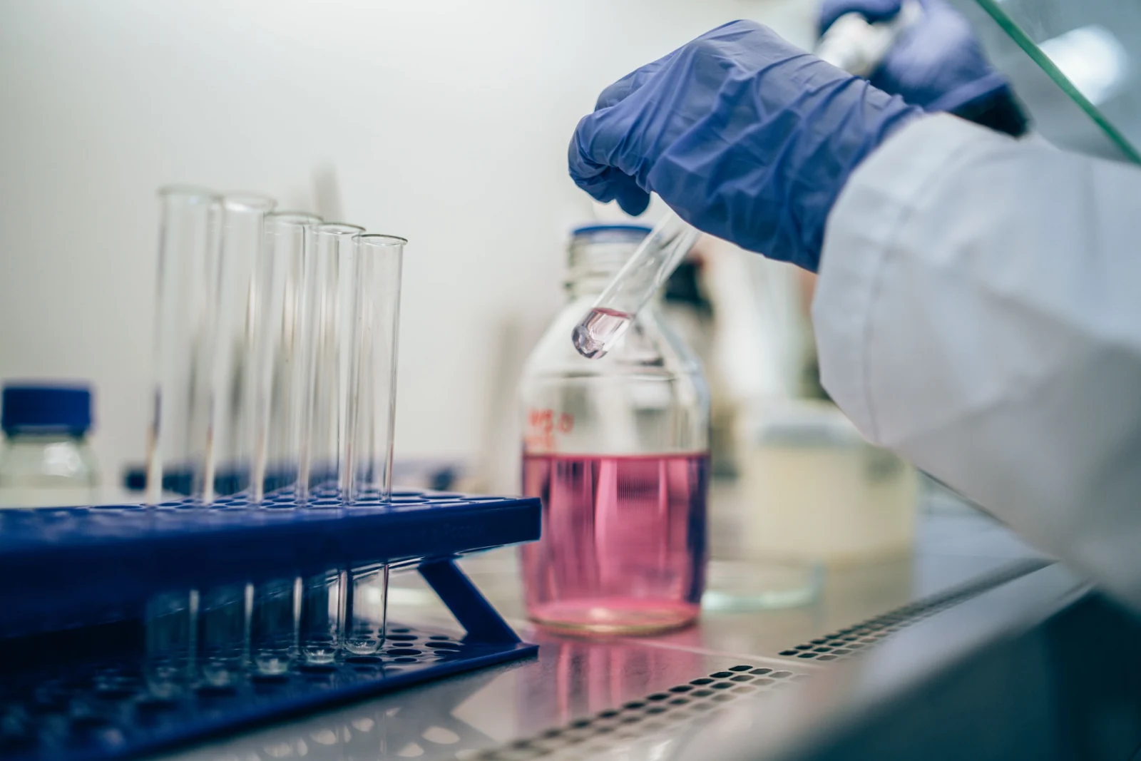 Gloved researcher working with laboratory glassware