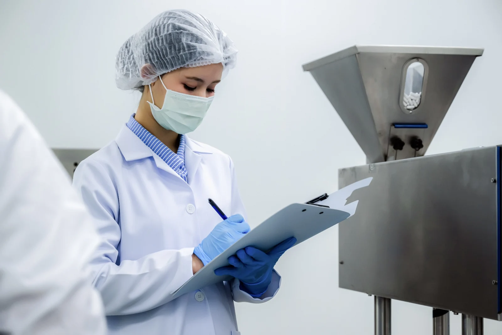 Operator reviewing production documentation beside equipment